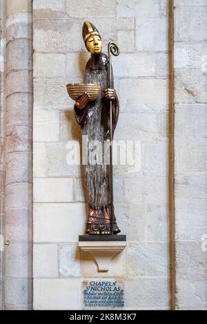 Innenraum der Romsey Abbey, einer normannischen Kirche in Romsey, Hampshire, England, Großbritannien. Statue des Heiligen Nikolaus von Peter Eugene Ball Stockfoto