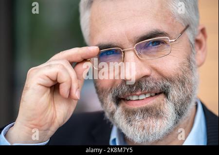 Kopfschuss eines bärtigen, gut aussehenden Mannes mittleren Alters in einer Brille Stockfoto