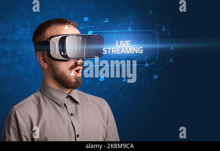 Geschäftsmann schaut durch Virtual Reality Brille, Social-Media-Konzept Stockfoto