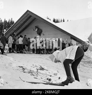 Hakadal 19630113 das neue Skigebiet Varingskollen wurde eröffnet, mit Sessellift, alpinen Loipen und Wanderwegen. Hier aus der Schlange am Aufzughaus. Das Aufzugshaus trägt das Varingskollen-Logo 'Kjerringa mit dem Pfahl' an der Münze. Die Frau im Vordergrund ist mit Stretchhose und Blasenjacke modisch. Foto: Thorberg / NTB / NTB Stockfoto