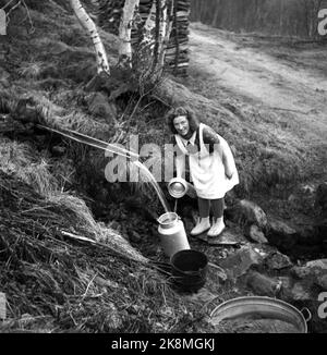 Loen 1947 etwas mehr als 10 Jahre nach dem großen Rennunfall ist das Leben in den Dörfern rund um Loen zurückgekehrt. Hier ist Anna Nesdal, die Wasser in einem Bach oder einer Quelle holt. Das Wasser wird in großen Milcheimern gesammelt. Foto: Th. Scotaam / Aktuell / NTB Stockfoto