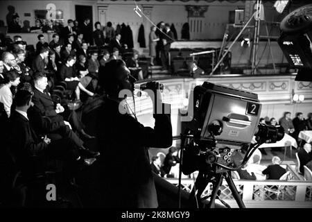 Oslo Januar 1964 - politische Fernsehdebatte im Central Theatre in Oslo. „Wo steht der Kommunismus?“ Zeigt das gesamte Fernsehteam in Aktion. Programmleiter Kjell Arnljot Perücke. Die Debatte bewegt sich zwischen dem Panel und dem Saal. 4 Kameras und 10 Mikrofone sind installiert. Der Kameramann hatte Durst und nimmt einen Schluck der Flasche. Foto: Aage Storløkken / Aktuell / NTB Stockfoto