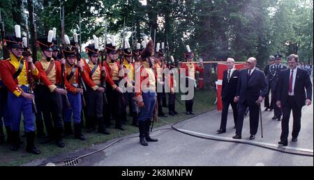 Eidsvoll 19890603 genau bei. 18,14 kam König Olav Eidsvoll an, um an dem historischen Stück "das Spiel über Eidsvold" teilzunehmen. Das Stück handelte vom Kampf um Norwegen nach dem Kieler Frieden und wurde vom Nationaltheater mit Unterstützung lokaler AmateurInnen im Rahmen des 175.. Jahrestages der Verfassung aufgeführt. Hier König Olav (in der Mitte) bei der Ankunft. Er passiert eine Reihe von Soldaten in alten und bunten Uniformen. Foto: NTB / NTB Stockfoto