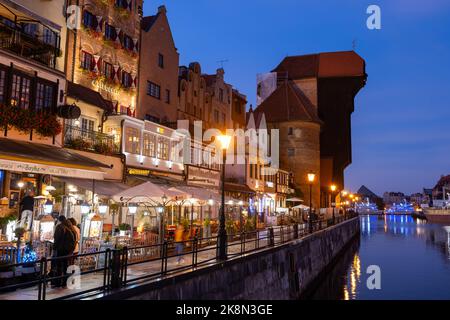 Danzig, Polen - 5. Oktober 2022: Stadt bei Nacht, Altstadt Skyline Abendansicht mit dem Kranich, historische Wohnhäuser, Restaurants auf Long EM Stockfoto