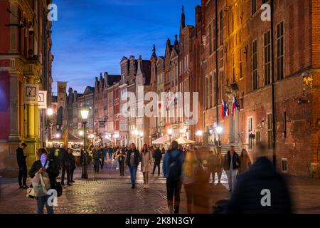 Danzig, Polen - 5. Oktober 2022: Abend in der Altstadt, die Menschen auf der lebhaften Long Street (Ulica Długa) gesäumt von historischen Bürgerhäusern in historischem c Stockfoto