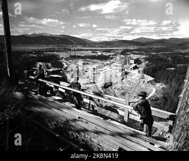 Rana 19520906: 'Abenteuerliche Dimensionen'. Die in Mo i Rana gebaute Eisenhütte ist nicht nur Norwegens größtes Unternehmen, sie ist auch eine ziemlich umstrittene Maßnahme. Die Umsetzung der schmiedeeisernen Pläne hat in unserer öffentlichen Diskussion starke Wellen ausgelöst. Das Bild: Die Bauarbeiter haben einen guten Blick auf das Zentrum von Rana, Ranzfjorden und die Umgebung. Foto: Sverre A. Børretzen / Aktuell / NTB Stockfoto