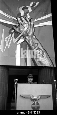 Oslo 19440515 Norwegen während des Zweiten Weltkriegs. Ministerpräsident Vidkun Quisling spricht auf dem Universitätsplatz in Oslo gegen das, was er die Verräter in London nennt, und den Kampf gegen den Bolschewismus. Quisling auf der Kanzel. Deutscher Adler und Sonnenkreuz auf der Kanzel. Im Hintergrund ein Propagandaplakat gegen den Bolschewismus. Eine Hand mit tätowierten russischen Symbolen, Sternen, Hammer und Sichel reißt das Kreuz aus der norwegischen Flagge. Foto: Kihle / NTB / NTB Stockfoto