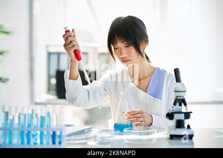 Wissenschaftlerinnen forschen in der Mikrobiologie mit Pipetten, Kolben und Reagenzgläsern, die in modernen chemischen Labors arbeiten. Medizin, Biotechnologie Konzept Stockfoto