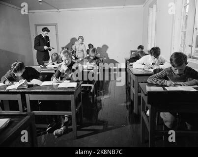 Nordkapp på Magerøya 195210. Europas nordligste internatskole ligger på Nordkapp i Repvåg. Åtte småsteder var skoleskøyta innom for å hente små passasjerer Fra 7 års alderen. Et par AV plasse hadde kai så skøyta kunne gå helt Inn, men som regel måtte den ligge utpå Og vente på robåten med ungen Og kofferten. Nordkapp herred--kommunen har skoleinternat for barna som bor på små avsidesliggende plasser innenfor herredsgrensene. Det er unger Fra anslagsvis 75 familier. Den første skoledagen etter sommerferien. Ihr ser vi lærer Kristen Nikolaisen som underviser klassen. Han er vikar für Bestirer Stockfoto