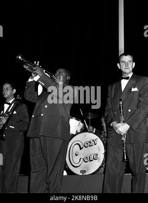 Oslo 1952; der Trompetengänger und Sänger Louis Armstrong (1901-1971) gab ein großartiges Konzert im Kolosseum-Kino in Oslo und trug damit maßgeblich zum Jazzfieber in der Hauptstadt im Jahr 50s bei. Die markante Stimme, das herausragende Trompetenspiel und das Besitzrecht des charmanten Künstlers an Armstrong zogen das Publikum an, das aus Enthusiasten bestand, die ebenfalls die Nacht in der Schlange verbracht hatten, um einen der über 2000 Sitzplätze im Kinosaal zu sichern. Hier spielt Armstrong ein Solo. Cozy Coles Bassdrum erscheint im Hintergrund auf der Bühne. Foto; Sverre A. Børretzen / Aktuell / NTB Stockfoto