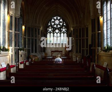 Eine Innenansicht der Kylemore Abbey mit einer betenden Frau in Connemara, County Galway, Irland Stockfoto