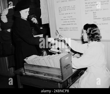 Oslo 19470503 - von der Gesundheitsstation Sagene im Jahr 1947. Hausfrauen mit Kindern auf Säuglingskontrolle, um über die richtige Ernährung und Anleitung in Säuglings- und Kleinkindpflege zu lernen. Die Task Control Station soll Krankheiten vorbeugen. Nachdem die Mutter eine neue Uhrzeit für die nächste Überprüfung des Kindes bestellt hat, wird das Nummernschild der Mutter übergeben. Heute stehen 49 Mütter vor ihr. Foto: Skotaam Current / NTB Stockfoto