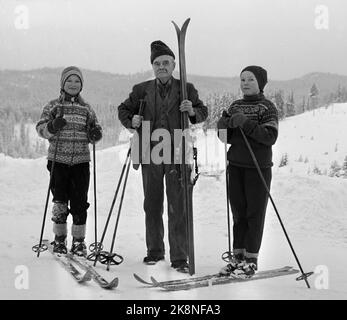 Telemark 19580220 Olav Bjaaland, der jüngste überlebende Polarforscher von Amundsens Südpol-Expedition, blickt zurück: Zusammen mit Roald Amundsen und drei weiteren Gefährten erreichte Polarfarer Olav Bjaaland (im Bild) am 14. Dezember 1911 als erster Mann den Südpol. Hier Bjaaland vor seinem Haus in Telemark, mit Skiern und zusammen mit zwei jungen Skifahrern, die die Telemark-Skistradition weiterführen. (Bjaaland wurde 1873 geboren und starb 1961) Foto: Knobelauch / NTB / NTB Stockfoto