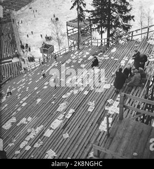 Holmenkollen, Oslo 19500318. Springen in Holmenkollbakken. Der Wind wehte das gesamte Holmenkollrennet weg, aber nach drei Stunden Verschiebung beruhigte er sich. 90.000 Zuschauer waren auf den Tribünen und in Sletta anwesend. Die Leute bringen Zeitungen in Holmenkollen zum Sitzen oder Stehen, aber sie vergessen, sie mitzunehmen, wenn sie gehen. So sah es aus, nachdem das Sprungrennen vorbei war. Tribuns. Foto: Sverre A. Børretzen / Aktuell / NTB Stockfoto