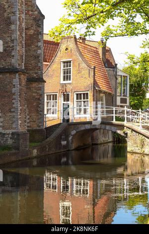 Blick auf die weiße Brücke über den Kanal im Stadtzentrum der historischen Stadt Delft. Stockfoto