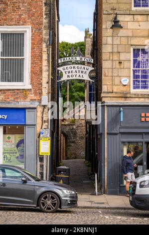 Richmond, North Yorkshire, Großbritannien - 3. August 2020: Traditionelles dekoratives schmiedeeisernes Schild für das Georgian Theatre Royal und die Brüder Wynd von der aus gesehen Stockfoto