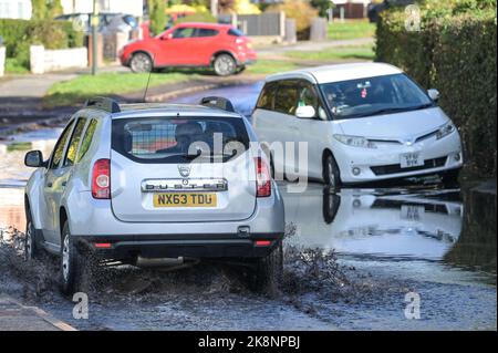 Yardley, Birmingham, 24. Oktober 2022. - Fahrer verhandeln sich am Montagnachmittag durch die Überschwemmungen auf der Yardley Green Road in der Yardley Gegend von Birmingham. Die Fahrer benutzten den Pfad auf der Seite, um entlang zu fahren und das tiefere Wasser zu vermeiden, aber einige Fahrer entschieden sich, durch die Mitte zu pflügen. PIC by Credit: Stop Press Media/Alamy Live News Stockfoto