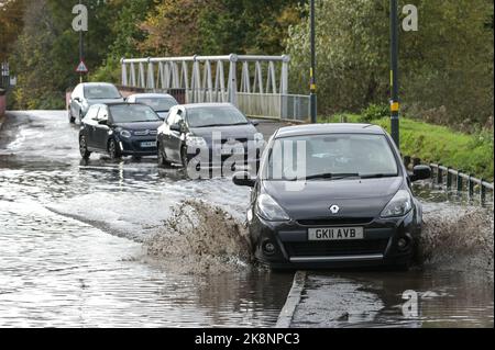 Yardley, Birmingham, 24. Oktober 2022. - Fahrer verhandeln sich am Montagnachmittag durch die Überschwemmungen auf der Yardley Green Road in der Yardley Gegend von Birmingham. Die Fahrer benutzten den Pfad auf der Seite, um entlang zu fahren und das tiefere Wasser zu vermeiden, aber einige Fahrer entschieden sich, durch die Mitte zu pflügen. PIC by Credit: Stop Press Media/Alamy Live News Stockfoto