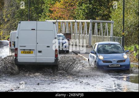 Yardley, Birmingham, 24. Oktober 2022. - Fahrer verhandeln sich am Montagnachmittag durch die Überschwemmungen auf der Yardley Green Road in der Yardley Gegend von Birmingham. Die Fahrer benutzten den Pfad auf der Seite, um entlang zu fahren und das tiefere Wasser zu vermeiden, aber einige Fahrer entschieden sich, durch die Mitte zu pflügen. PIC by Credit: Stop Press Media/Alamy Live News Stockfoto