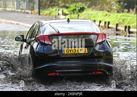 Yardley, Birmingham, 24. Oktober 2022. - Fahrer verhandeln sich am Montagnachmittag durch die Überschwemmungen auf der Yardley Green Road in der Yardley Gegend von Birmingham. Die Fahrer benutzten den Pfad auf der Seite, um entlang zu fahren und das tiefere Wasser zu vermeiden, aber einige Fahrer entschieden sich, durch die Mitte zu pflügen. PIC by Credit: Stop Press Media/Alamy Live News Stockfoto