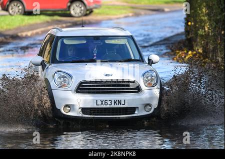 Yardley, Birmingham, 24. Oktober 2022. - Fahrer verhandeln sich am Montagnachmittag durch die Überschwemmungen auf der Yardley Green Road in der Yardley Gegend von Birmingham. Die Fahrer benutzten den Pfad auf der Seite, um entlang zu fahren und das tiefere Wasser zu vermeiden, aber einige Fahrer entschieden sich, durch die Mitte zu pflügen. PIC by Credit: Stop Press Media/Alamy Live News Stockfoto