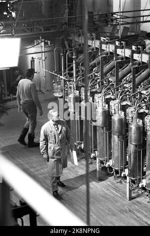 Rjukan Januar 1965 Filmaufnahme von 'Heroes from Telemark' in Rjukan. Über die schweren Wassersaboteure von Kompani Linge. Sabotage zum Kraftwerk Vemork. Die britische Firma Benton Film posiert mit 120 Mitarbeitern. Die heiße Nummer eins ist der amerikanische Schauspieler Kirk Douglas. Der Nachtwächter geht seine Runde in der Fabrik. Foto: Sverre A. Børretzen / Aktuell / NTB Stockfoto