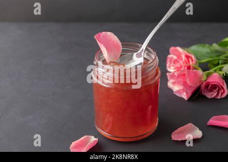 Glas Rosenblütenstaub auf dunklem Hintergrund mit Kopierraum Stockfoto