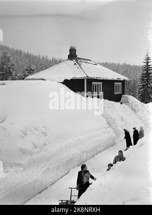 Südnorwegen, Februar 1951: Starker Schneefall über dem südlichen Teil des Landes verursachte wochenlang Chaos. Hier das Haus für den Kaufmann Gunnar Seland, mit Geschäft im Erdgeschoss. Seland kann leicht aus dem 2.. Stock und direkt in die Schneefälle gehen. Die Kunden werden nach dem erneuten Schnee auf den Landstraßen zum Skifahren und Kicking überwiesen. Foto: Arne Kjus / Aktuell / NTB Stockfoto