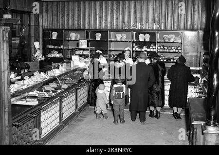 Oslo 19530201 Interieur aus Møllhausen Konditori im Karl Johans Tor. Hier aus der Bäckerei. Kunden an der Theke, darunter zwei kleine Kinder. Weibliche Disponenten mit weißen Schürzen und Schnitten hinter dem Tresen. Foto: NTB / NTB Stockfoto