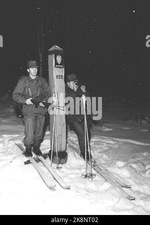 Grenze Jakobselv, Finmark Dezember 1962. Verteidigungsminister Gudmund Harlem soll an die Grenze zu Jakobselv mit Weihnachtsgeschenken für die Männer gehen, die über die Grenze zur Sowjetunion sprechen. Die Reise dauerte 5 Tage und wurde zu einer harten Reise mit Flugzeug, Auto, Boot und Pulk. Hier auf dem Grenzspiel Nr. 122 standen Kåre Bjørkli und Einar Johansen (mit Fernglas) und beobachteten, dass an der norwegisch-sowjetischen Grenze alles ruhig war. Die Patrouille hat immer eine tolle Verpackung. Das Wetter kann sie dazu zwingen, die Nacht unter freiem Himmel zu kippen. Foto: Ivar Aaserud Current / NTB Stockfoto