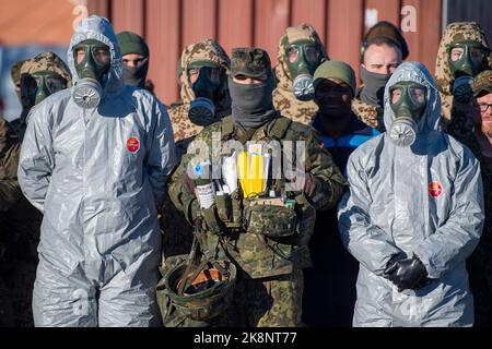 Tallin, Estland. 24. Oktober 2022. Soldaten der Bundeswehr stehen nach einer Dekontaminationsübung im Hafen mit ihren Schutzanzügen und Gasmasken zusammen. Inspektoren der Luftstreitkräfte und der Marine besuchen Estland während des fast einmonatigen Manövers „Baltic Tiger 2022“. Marine- und Luftstreitkräfte üben den Schutz kritischer Infrastrukturen an der Ostflanke der NATO in Estland aus. Quelle: Christophe Gateau/dpa/Alamy Live News Stockfoto