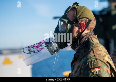 Tallin, Estland. 24. Oktober 2022. Ein Bundeswehrsoldat steht bei einer Dekontaminationsübung im Hafen mit einer Gasmaske. Inspektoren der Luftwaffe und der Marine besuchen Estland für das Baltic Tiger 2022-Manöver, das knapp einen Monat dauern wird. Marine- und Luftstreitkräfte üben den Schutz kritischer Infrastrukturen an der Ostflanke der NATO in Estland aus. Quelle: Christophe Gateau/dpa/Alamy Live News Stockfoto