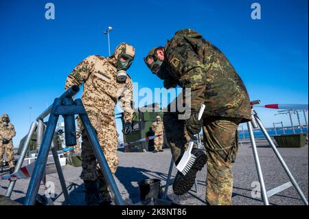 Tallin, Estland. 24. Oktober 2022. Soldaten der Bundeswehr stehen bei einer Dekontaminationsübung im Hafen mit Schutzanzügen und Gasmasken. Inspektoren der Luftstreitkräfte und der Marine besuchen Estland für das fast einmonatige Baltic Tiger 2022-Manöver. Marine- und Luftstreitkräfte üben den Schutz kritischer Infrastrukturen an der Ostflanke der NATO in Estland aus. Quelle: Christophe Gateau/dpa/Alamy Live News Stockfoto