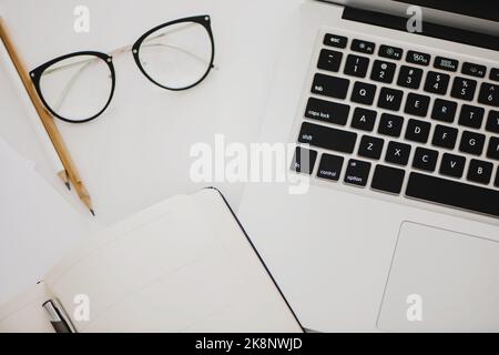 Draufsicht auf den Arbeitsbereich, Schreibtisch mit Laptop-Notebook, Brille und Bleistift. Stockfoto