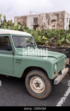 Altes Offroad-Auto vor einem Haus voller Kakteen Stockfoto