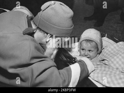 Oslo 195412 - Kinder treffen den Weihnachtsmann. Das kleine Mädchen starrt erschrocken auf den Weihnachtsmann. Angst bekommen. Sitzen in einem Kinderwagen. Snacks. Foto: Aage Storløkken / Aktuell / NTB Stockfoto