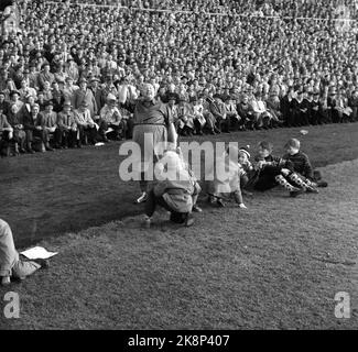 Oslo, 19561021. Das Pokalfinale im Ullevaal Stadium. Larvik Turn - Skeid 1-2. Skeid-Unterstützer und Revue-Künstler Einar Rose winkt ein Wimpel. Kleine Jungen am Rande sehen ihn seltsam an. Foto: Current / NTB Stockfoto