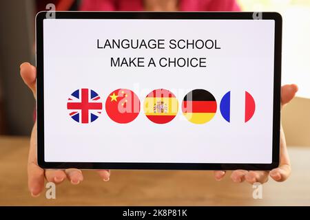 Weibliche Hände halten Tablet mit offener Sprachschulanwendung Stockfoto