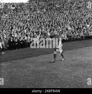 Oslo, 19561021. Das Pokalfinale im Ullevaal Stadium. Larvik Turn - Skeid 1-2. Skeid-Unterstützer und Revue-Künstler Einar Rose winkt ein Wimpel. Kleine Jungen am Rande sehen ihn seltsam an. Foto: Current / NTB Stockfoto