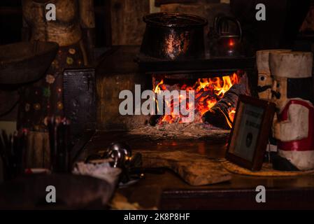 Holzofen mit Feuerflammen in einer dunklen rustikalen Küche in Minas Gerais, Brasilien. Stockfoto