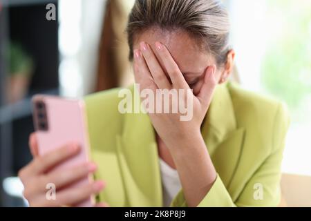 Frustrierte depressive Frau, die das Gesicht mit der Hand bedeckt Stockfoto