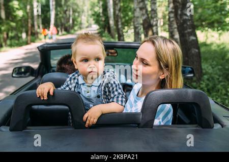 Mama, Papa und kleiner Sohn in einem Cabriolet. Sommer Familienausflug in die Natur Stockfoto