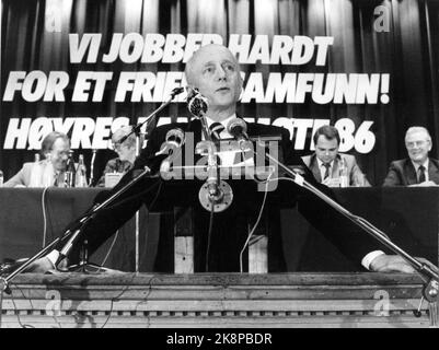 Oslo 19860418: Nationales Treffen der Rechten. Premierminister Kåre Willoch auf der Kanzel, mit Mikrofonen, Slogans im Hintergrund "Wir arbeiten hart für eine freiere Gesellschaft! Nationalversammlung der Rechten 86“. Foto Bjørn Sigurdsøn Stockfoto