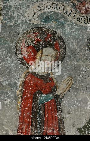 Die heilige Katharina von Alexandria kniet im Gebet, als sie auf ihre Enthauptung wartet. Detail der vorletzten Platte im mittelalterlichen Freskenzyklus im Ulmer Münster oder Münster, der lutherischen Kirche in Ulm, Baden-Württemberg. Die Heilige Katharina war eine christliche Jungfrau-Märtyrerin aus den 300er Jahren und der Freskenzyklus erzählt die Geschichte ihres Lebens und ihres Todes auf Befehl des römischen Kaisers Maxentius. Stockfoto