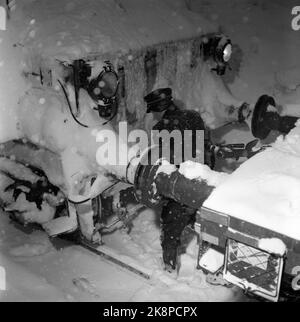 Kragerø 19540320. Südnorwegen steht kurz vor dem Erwürgen durch Schnee. Im Februar kippte der Schnee 23 Tage lang Tag und Nacht. Straßen waren blockiert, Züge schneiten hinein, Autos verschwanden unter den Schneemassen, an vielen Stellen fast nur der Schornstein, der über den Häusern hing. Der Schnee lag meterhoch in den Straßen und der Schnee Tag und Nacht. Die Menschen kämpften als Terrier, um die Hauptlinie offen zu halten. Im Schnee versuchten die Züge auf der Sørlandsbanen, voranzukommen. Foto: Aage Storløkken / Aktuell / NTB Stockfoto