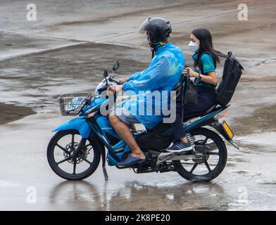 SAMUT PRAKAN, THAILAND, Okt 11 2022, Ein Moto-Taxi fährt mit Passagier im Regen Stockfoto