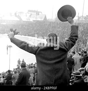19520219 Oslo: Olympische Spiele, Winterolympiade, Schlittschuhlauf, schnelles Rennen, 10.000 Meter: Große Menschenmassen folgten den Rennen im Bislett Stadium. Tolle Atmosphäre, als Hjalmar Andersen auf 10.000 Metern Gold gewann. Mann mit Hut und Mantel steht auf und jubelt. Foto: Current / NTB Stockfoto