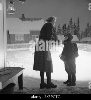 Aurskog 11 February 1956 'Diese Kinder haben 3 Meilen Schulstraße' die jungen Kinder Kjell aus Nybak, Hallvard aus Sinkerud und Marit aus Stenshaugen müssen 6 km allein durch den nächtlichen Schwarzwald laufen, bevor sie den Schulbus in Bekkesaga erreichen. Sie müssen um 5 Uhr aufstehen, um den Bus zu erreichen, der zur Haneborg-Schule in Aurskog fährt. Kjell auf Nybak sagt Auf Wiedersehen zu seiner Mutter, bevor er sich auf die Schulstraße durch den Wald begibt. Foto; Sverre A. Børretzen / Aktuell / NTB Stockfoto