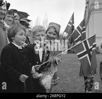 Oslo 19570517 May 17 die Feier in Oslo wurde zu einem ziemlich coolen Erlebnis, aber das dämpfte die Feierlichkeiten nicht. Hier sind drei glückliche Kinder mit Fahnen vor dem Schloss. Foto: NTB / NTB Stockfoto