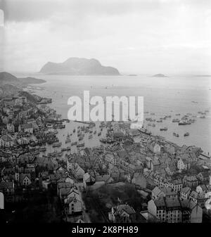 Ålesund 19480413: 100.-jähriges Jubiläum der Stadt Ålesund. Der Jahrestag wurde in vielerlei Hinsicht gefeiert, unter anderem mit einer großen Flottenparade, bei der 600 große und kleine Boote mit 10.000 Mann an Bord an dem König und dem Kronprinzen, die an Bord des Fischereischiffs waren, vorbeischerten. Die strömenden Regenfälle dämpften die Partyatmosphäre nicht. Hier ist ein Übersichtsbild von der Flottenparade, die aus Ålesundet stammt. Ålesund Stadt im Vordergrund, Øya Godøy im Hintergrund. Foto: Current / NTB Stockfoto